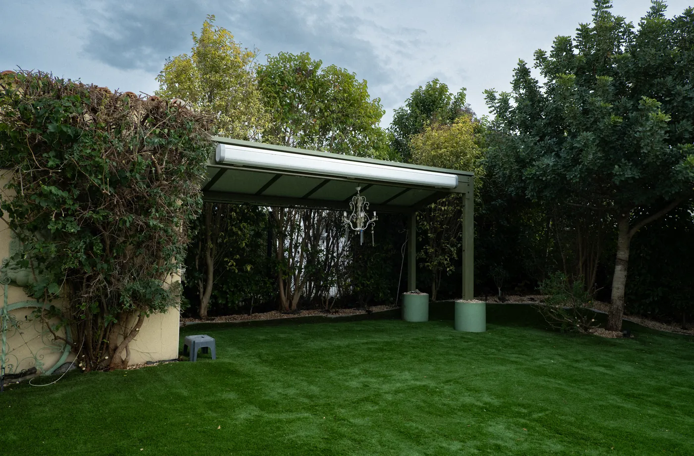 APRÈS — même pergola verte dégagée, pelouse impeccable et vue retrouvée — Vertical Élagage